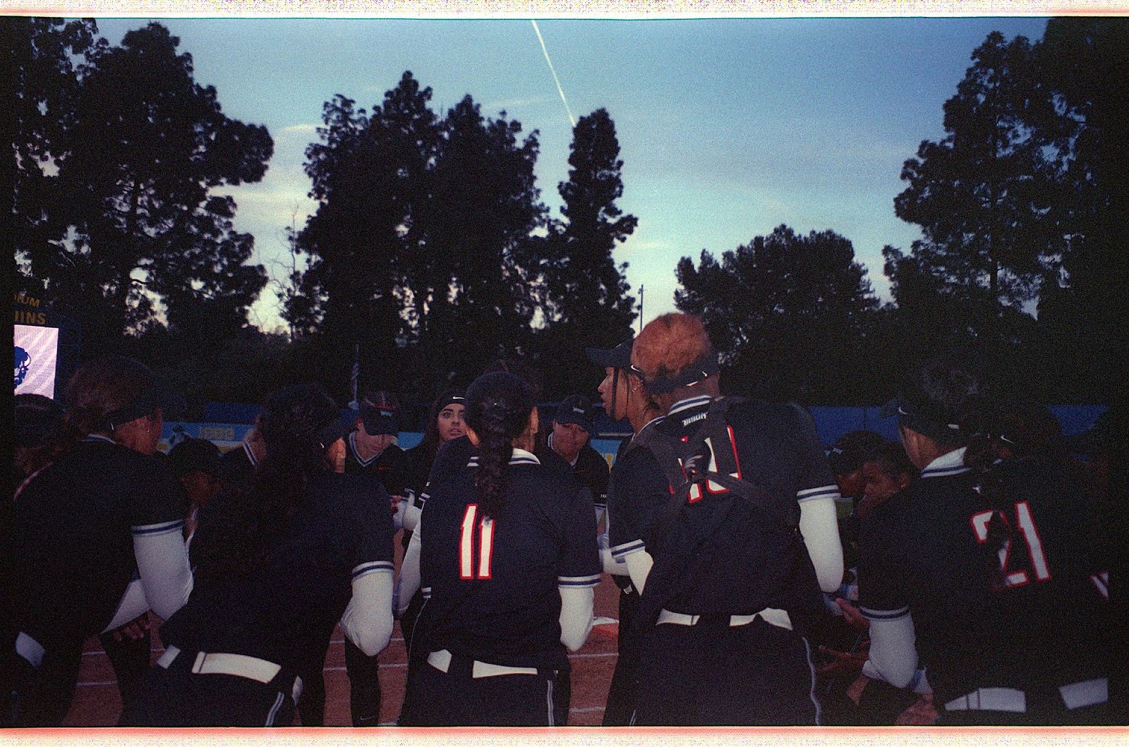 Softball huddle — film photograph by Maxie Harrington